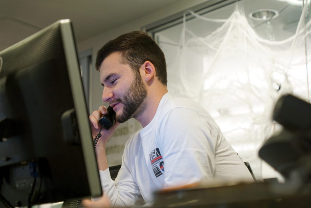 Photo of student employee helping people at Library Help Desk