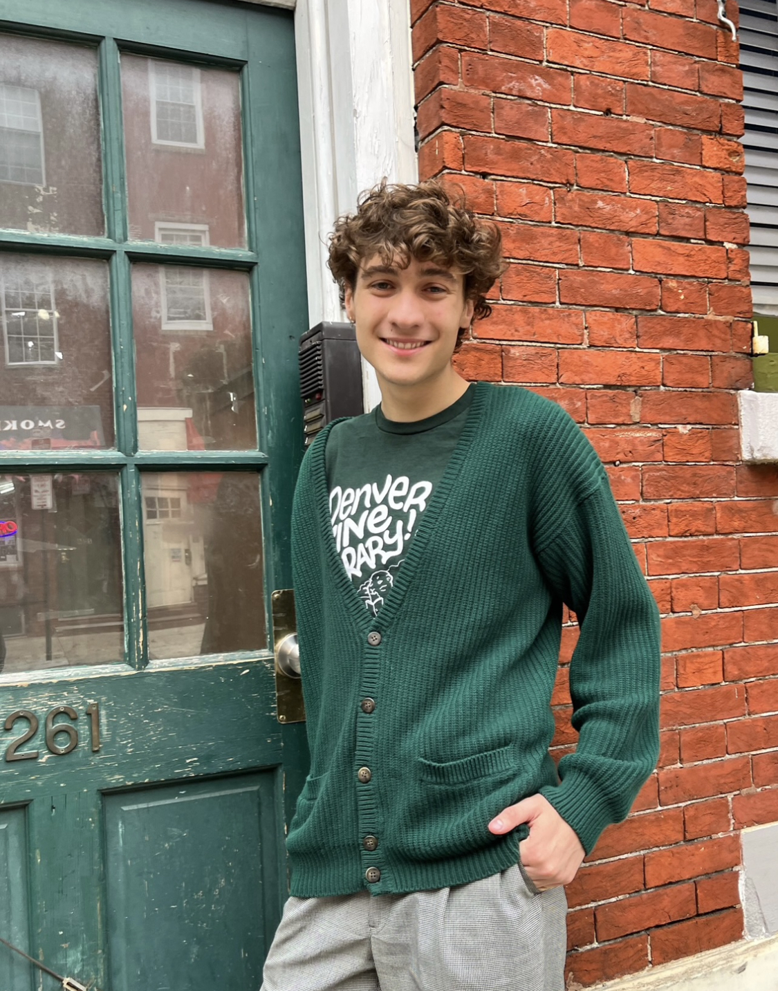 Maxmimus Vogt posing in front of a door, wearing a CSU green sweater