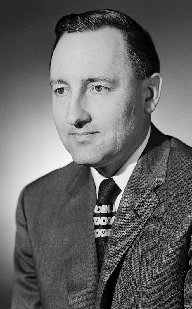 1958 black and white photograph of Professor Norm Evans wearing a suit and a stylish necktie. 