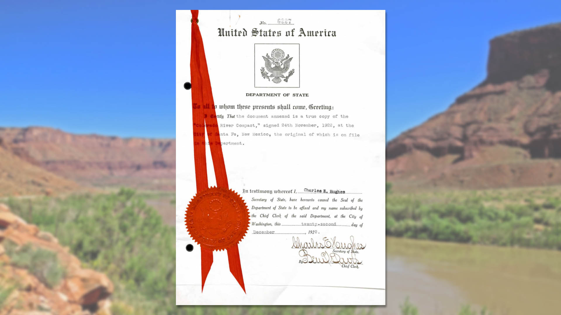 Colorado River Compact historical document emblazoned with a government seal, superimposed on a photo of the river itself. 