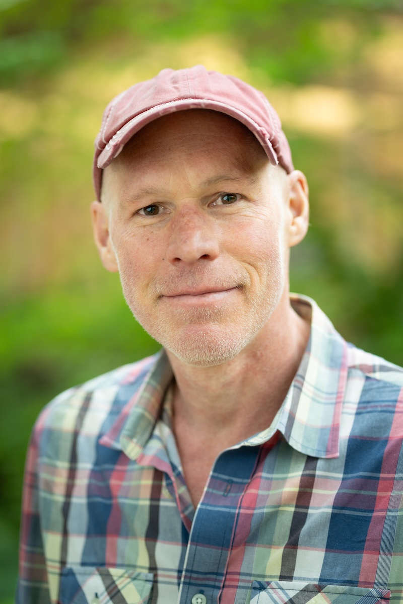 A headshot of Rob Sica, a white man in a baseball cap and plaid shirt